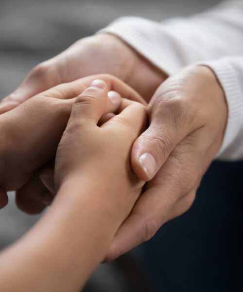 Close up mother supporting, touching adorable little daughter hands, family enjoying tender moment, expressing love and care, mum comforting, caressing kid, childcare, children protection concept